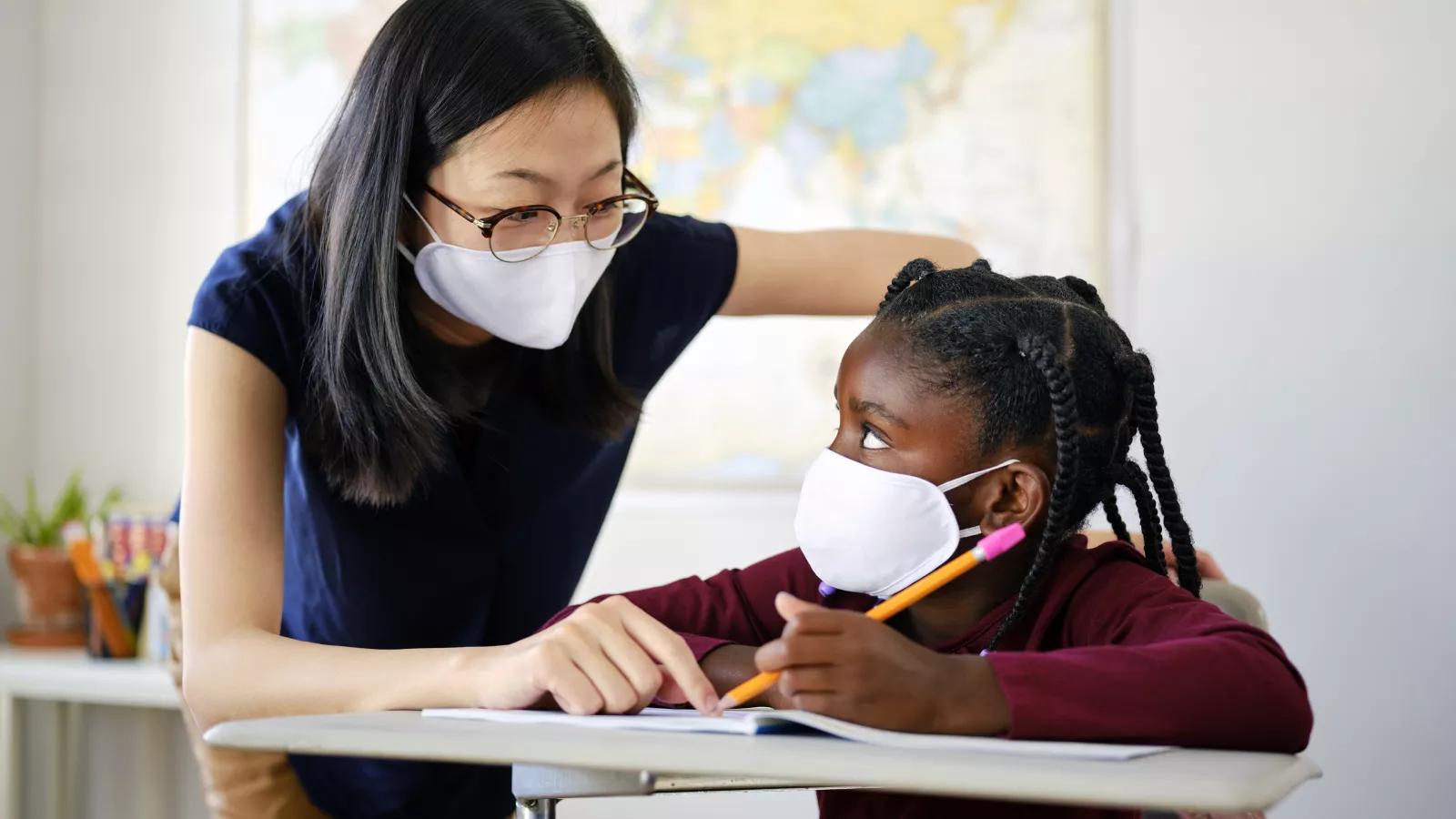 A student and teacher wear masks