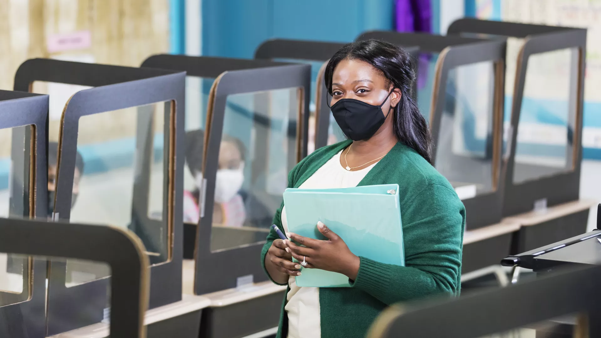 Masked teacher with desks