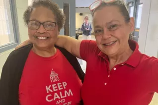 two LAE members in Red for Ed pose for a picture together in a school hallway
